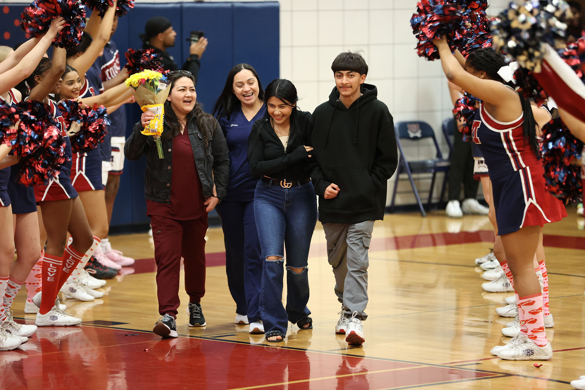 Basketball Student Trainer and her family smiling as they are introduced