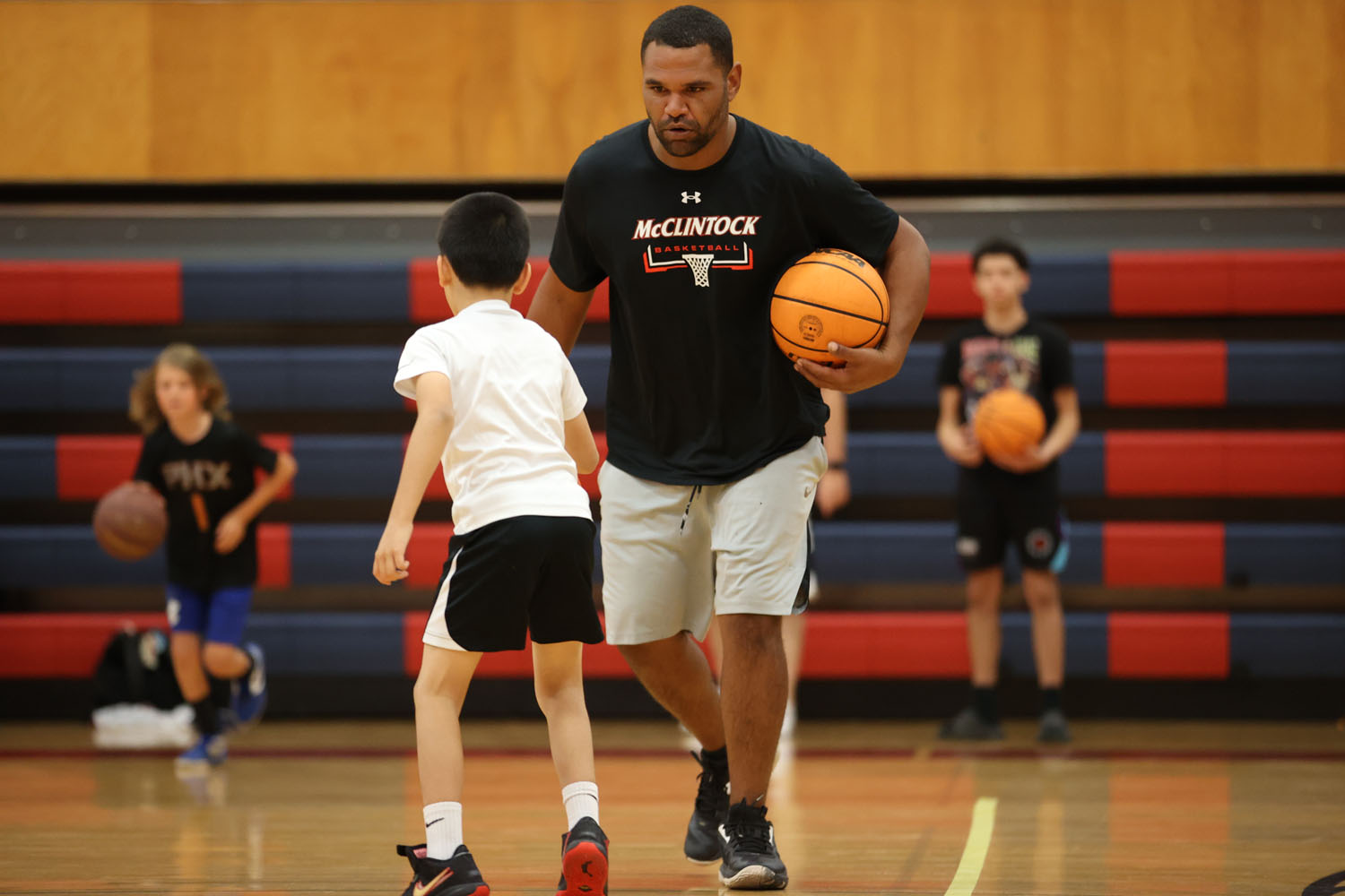 Coach helping a camper learn to dribble